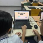 A picture depicting students on a laptop doing a project using Artificial Intelligence as part of their Digital Literacy Education.